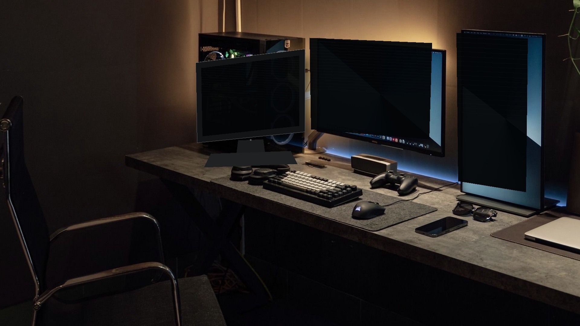 Empty professional developer workstation with three monitors and an empty chair